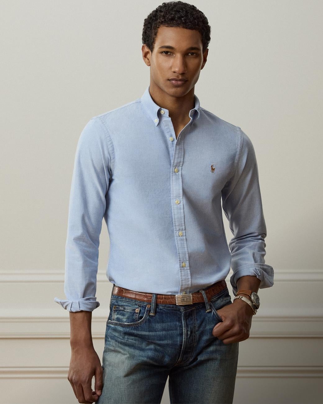 Man wears blue Slim Fit button-down shirt and jeans.